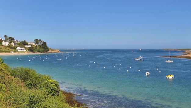 Meerblick mit Booten und Dorf an der Küste im Aber Benoit in Bretagne Frankreich