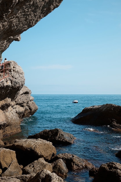 Meerblick von einer felsigen Höhle, Boot im Meer, Felsen und Felsen, Meereslandschaft