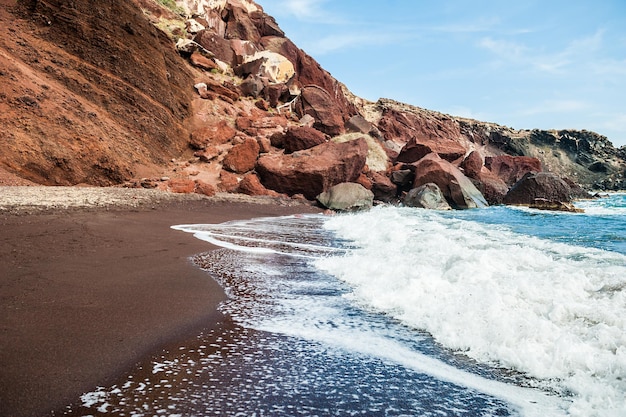 Meeresbrandung am schönen roten Strand. Santorin, Griechenland