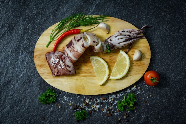 Meeresfrüchte gegrillter kalmar mit kräutern und gewürzen zitronentomate-chili-knoblauch und dill auf schneidebrett