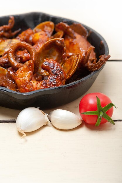 Meeresfrüchte in der Pfanne mit Knoblauch und Tomaten auf dem Tisch