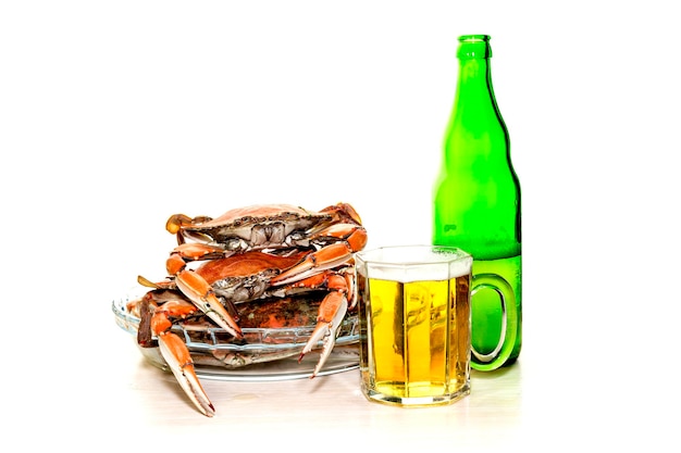 Meeresfrüchte Leckere frisch gekochte Krabben und Bier in einer Flasche und einem Becher in der Nähe auf weißem Hintergrund