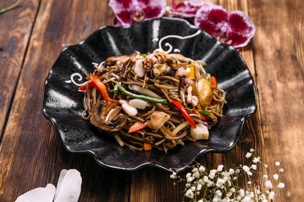 Meeresfrüchte Soba Nudeln Wok in einem schwarzen Teller