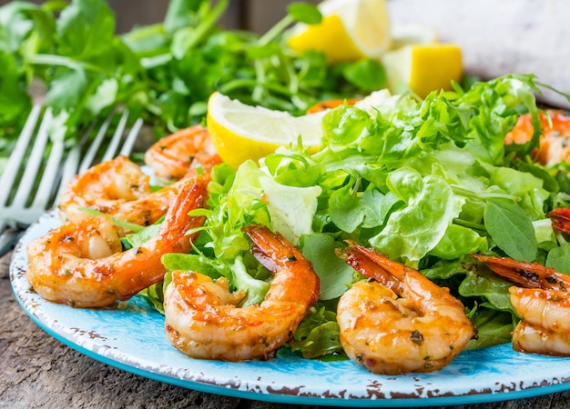 Foto meeresfrüchtegarnelen-kopfsalatsalat auf blauer platte