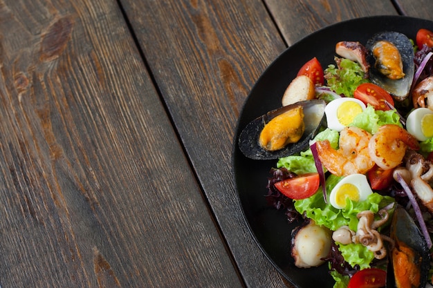 Meeresfrüchtesalat auf Teller auf Holz