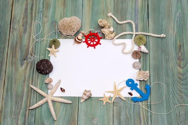 Foto meereshintergrund mit muscheln und seesternen und einem stück papier auf einem holztisch