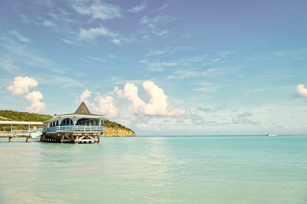 Meeresstrand mit Holzhütte an einem sonnigen Tag in Antigua Pier in türkisfarbenem Wasser auf blauem Himmelshintergrund Sommerurlaub in der Karibik Wanderlust-Reise Abenteuer-Entdeckungsreise