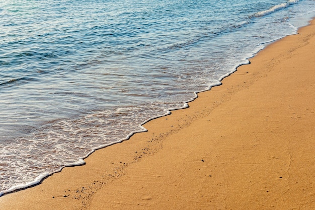 Meereswelle mit Schaum am Sandstrand