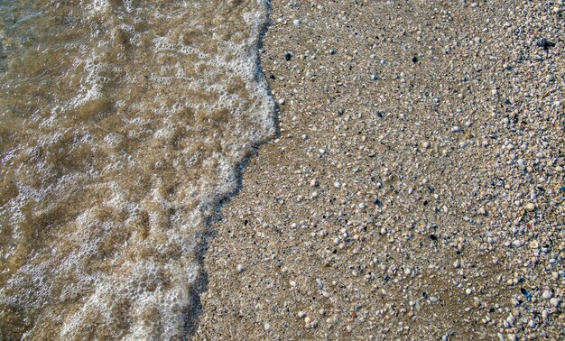 Meereswellen am Ufer mit Muscheln Schöner Hintergrund