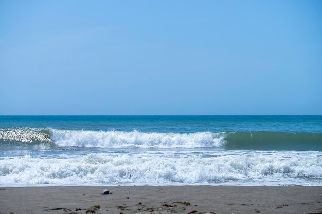 Meereswellen, die am Sandstrand brechen Meereswellen, die an der Küste des Mittelmeers brechen