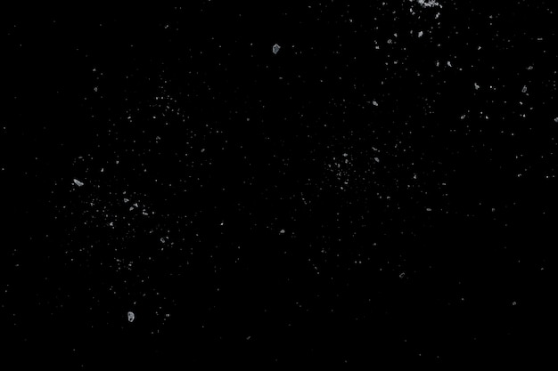 Meersalzkristalle auf einer schwarzen Oberfläche.