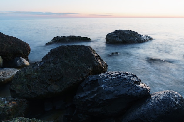 Meerwasser, das die Felsen an der Küste wäscht. Eine Langzeitbelichtung des Meeres