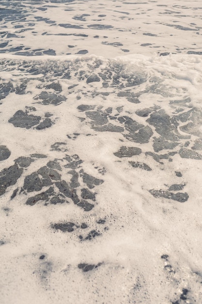 Meerwasser von einer Welle mit Schaum an der Küste