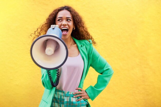 Foto megafone de mulher e anúncio em fundo amarelo de revisão de fala e maquete atenção feminina e voz para notícias de áudio e transmissão de opinião simulam espaço e geração z falando no alto-falante