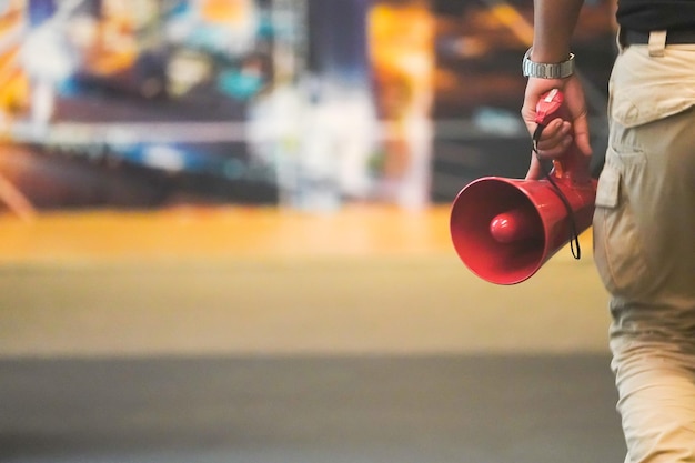 Megafone vermelho na mão do homem com fundo desfocado