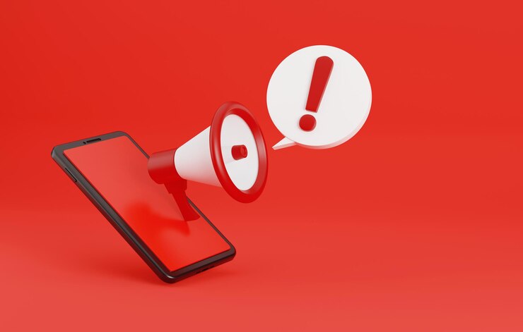 Foto megáfono con burbuja de chat de alerta de seguridad y teléfono inteligente aislado sobre fondo rojo