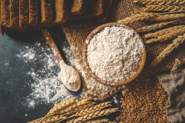 Mehl in einer Holzschüssel, frisches hausgemachtes Brot und Maiskörner, Banner der Bäckerei