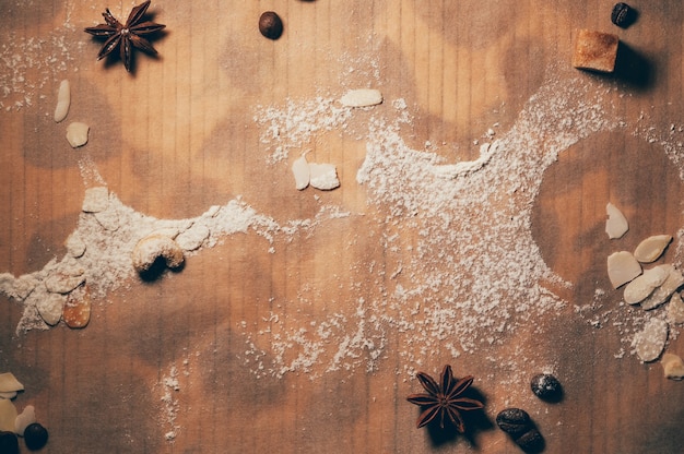 Mehlpulver auf strukturiertem Papierhintergrund Nüsse Kaffeebohnen und Gewürze Kochprozess