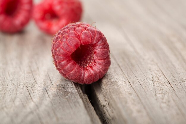 Mehrere Beeren Himbeere auf dem alten Holztisch Nahaufnahme