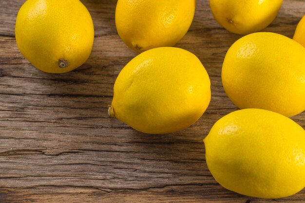 Mehrere frische saftige Zitronen auf Holzuntergrund