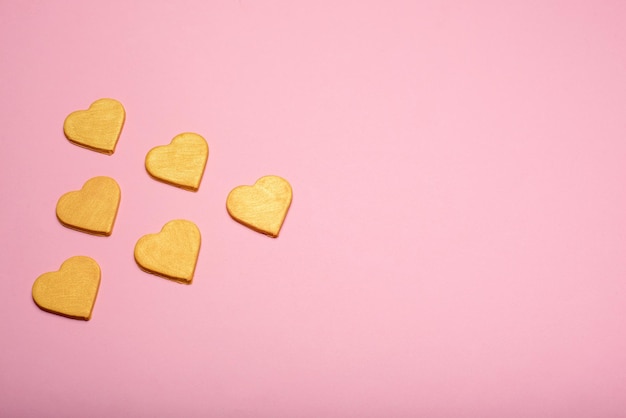 Mehrere gelbe Herzen auf einem rosa Hintergrund