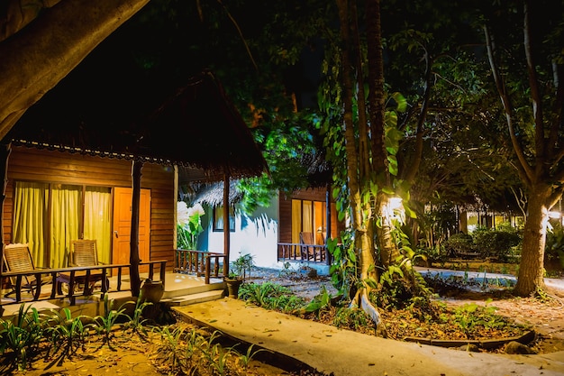 Mehrere Holzhäuser gebaut Wald Dschungel bei Nacht mit Bungalows Reihe Viel Grün Vegetation