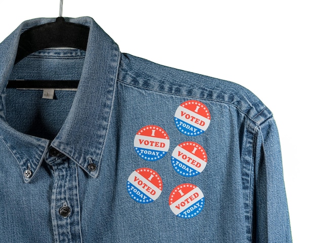 Mehrere „i voted today“-aufkleber auf dem arbeitshemdkragen aus blauem denim für zwischenwahlen in den usa mit weißem hintergrund