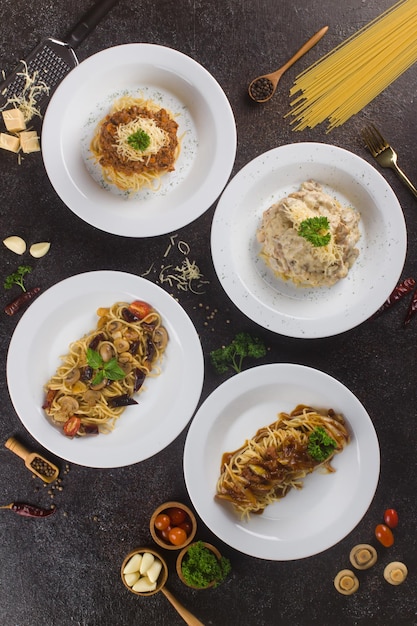 Mehrere italienische Pasta-Spaghetti mit Bolognese-Fleischsauce und Parmesan auf Texturtisch