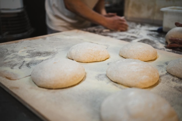 Mehrere Kugeln frischer Brotteig nach dem Vorformen in der handwerklichen Bäckerei