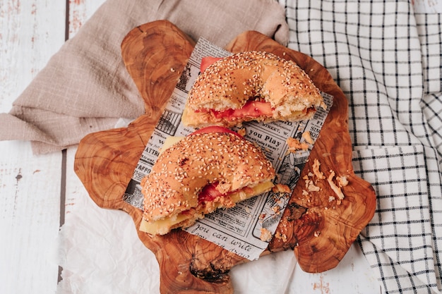 Mehrere mit Sesam und Chia-Brot halbierte Bagels enthalten verschiedene Zutaten wie Tomaten, Schinken, Avocado, Frischkäse und Hühnchen in Streifen.