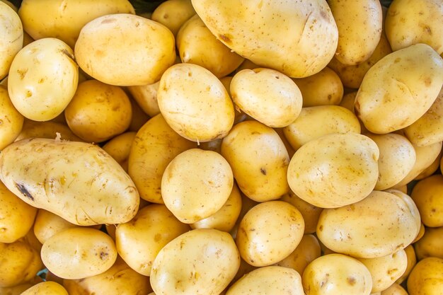 Foto mehrere schöne gelbe kartoffeln auf einem hölzernen straßenmarktstand