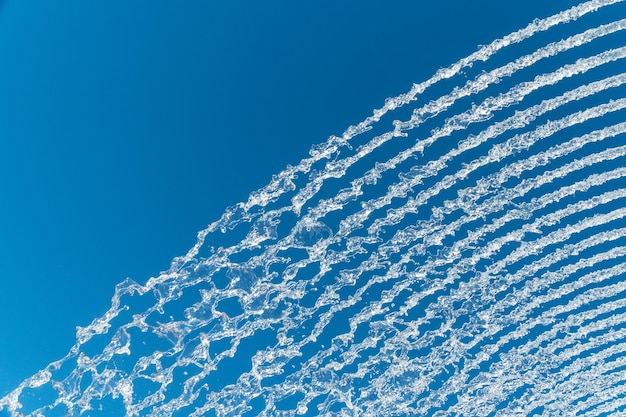 Mehrere Wasserstrahlen und Spritzer über einem tiefblauen Himmel