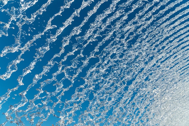 Mehrere Wasserstrahlen und Spritzer über einem tiefblauen Himmel