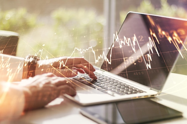 Mehrfachbelichtung abstrakter kreativer Finanzdiagramme mit Handeingabe auf Laptop auf Hintergrund-Devisen- und Anlagekonzept