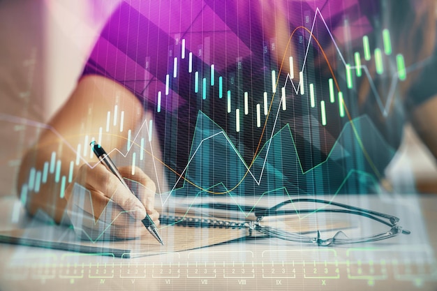 Mehrfachbelichtung von Frauenhänden, die mit dem Forex-Diagramm-Hologramm Notizen machen. Konzept der technischen Analyse