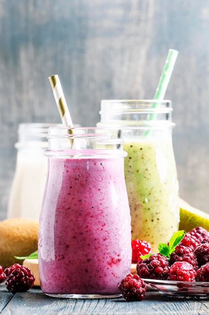 Mehrfarbige Beeren- und Fruchtsmoothies, sortiert in Glasflaschen, selektiver Fokus