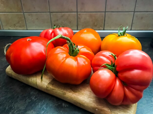 Mehrfarbige frische Tomaten auf hölzernem Küchenbrett.