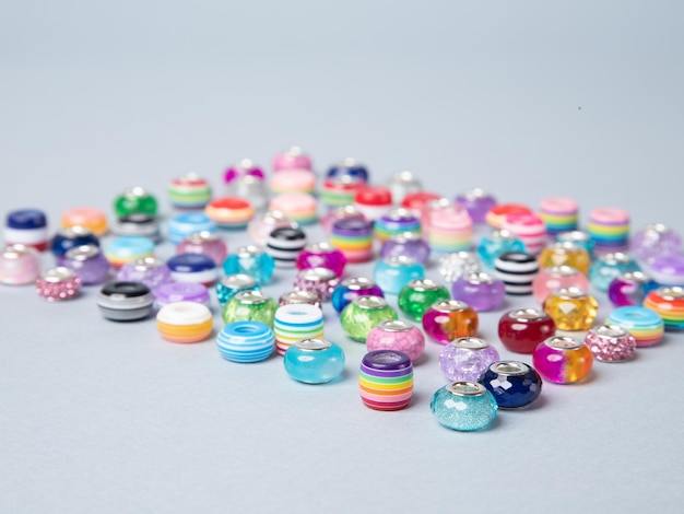 Mehrfarbige Perlen sind auf blauem Hintergrund verstreut Closeup Makro Veredelung von modischer Kleidung machen eine Perlenkette Fashionista Perlen Perlen häkeln Tägliche Perlenstickerei