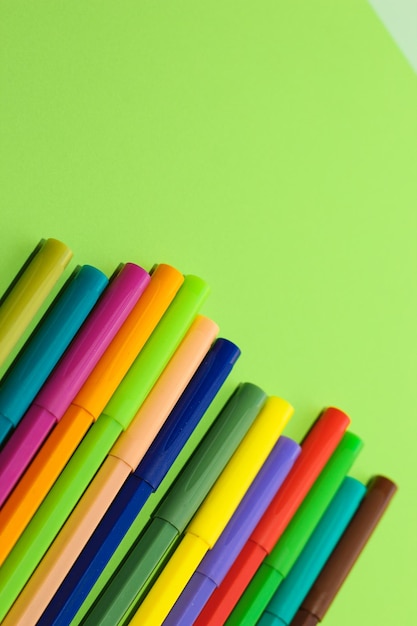 Mehrfarbige Schreibwaren-Filzstifte auf einem Hintergrund aus mehrfarbigem Kartonpapier