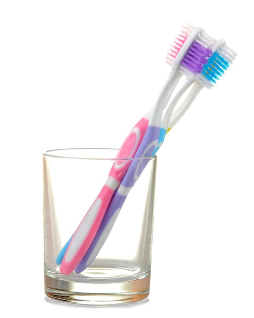 Mehrfarbige Zahnbürsten in einem Becherglas auf einem weißen isoliert. Mundhygiene.