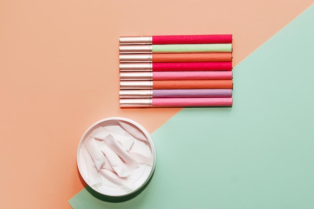 Mehrfarbige Zigaretten und Snus-Pads auf Papierhintergrund das Konzept einer schlechten Angewohnheit