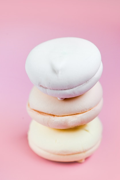 Mehrfarbiger Marshmallow auf rosa Hintergrund. bunte Süßigkeiten. köstlicher und schöner Zephyr. Speicherplatz kopieren