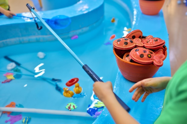 Mehrfarbiger Plastikspielzeugfisch im Pool für das Angelkonzeptspiel der Kinder