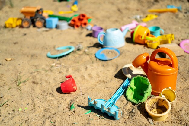 Mehrfarbiges Kinderspielzeug aus Plastik im Sandkasten.