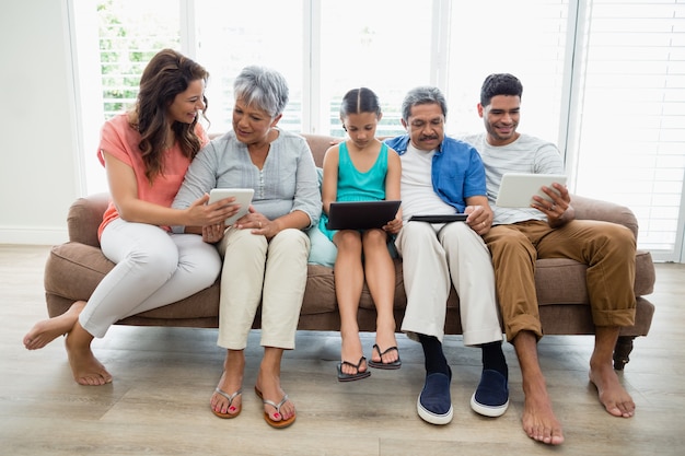 Mehrgenerationenfamilie mit digitalem Tablet im Wohnzimmer