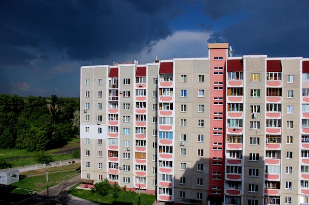 Mehrstöckiges modernes Haus auf dem Hintergrund sehr dunkler Regenwolken