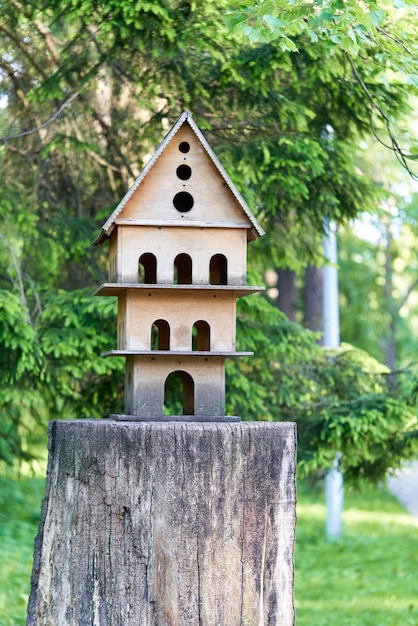 Mehrstöckiges Vogelhaus auf einem Baumstumpf im Park