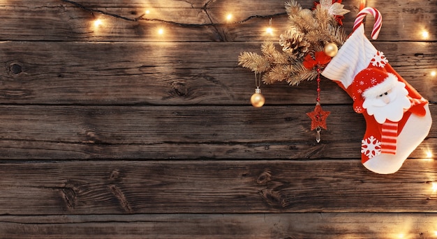 Meia de Natal com presentes pendurados no fundo escuro de madeira velha