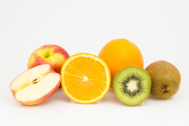 Meia maçã, laranja e quivi isolados do corte no branco.