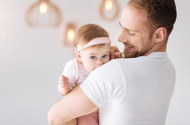 Mein liebes Kind. Freudig entzückter bärtiger Vater, der zu Hause steht und das Kleinkind umarmt, während er zarte Gefühle ausdrückt